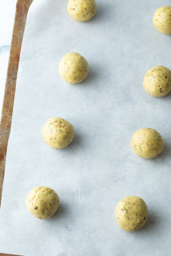 8 balls of cookie dough on a baking sheet.