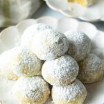 Pyramid stacks of almond and pistachio Italian wedding cookies dusted with powdered sugar.