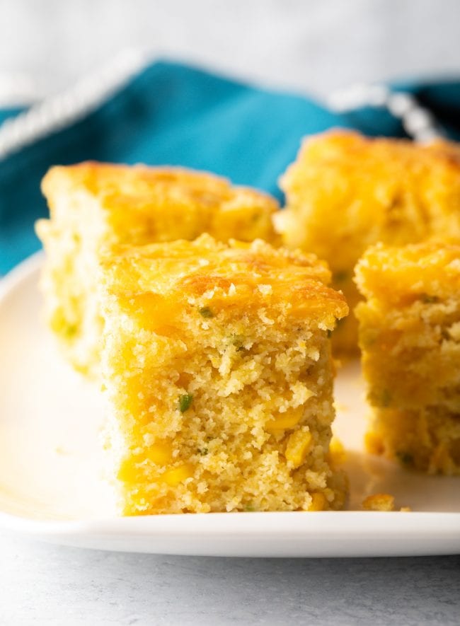 cut squares of homemade cheesy cornbread with jalapenos