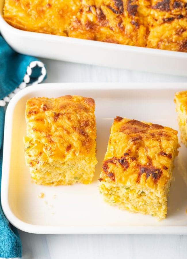 overhead view squares of baked cornbread on a white platter