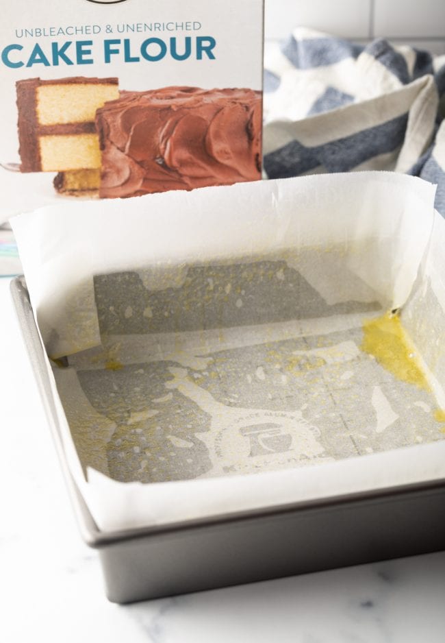 parchment paper lined baking square with box of cake flour in the background