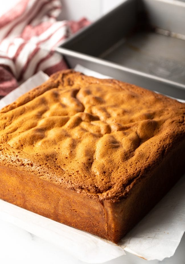 Baked Japanese Sponge Cake removed from the pan and sitting on a piece of parchment paper.