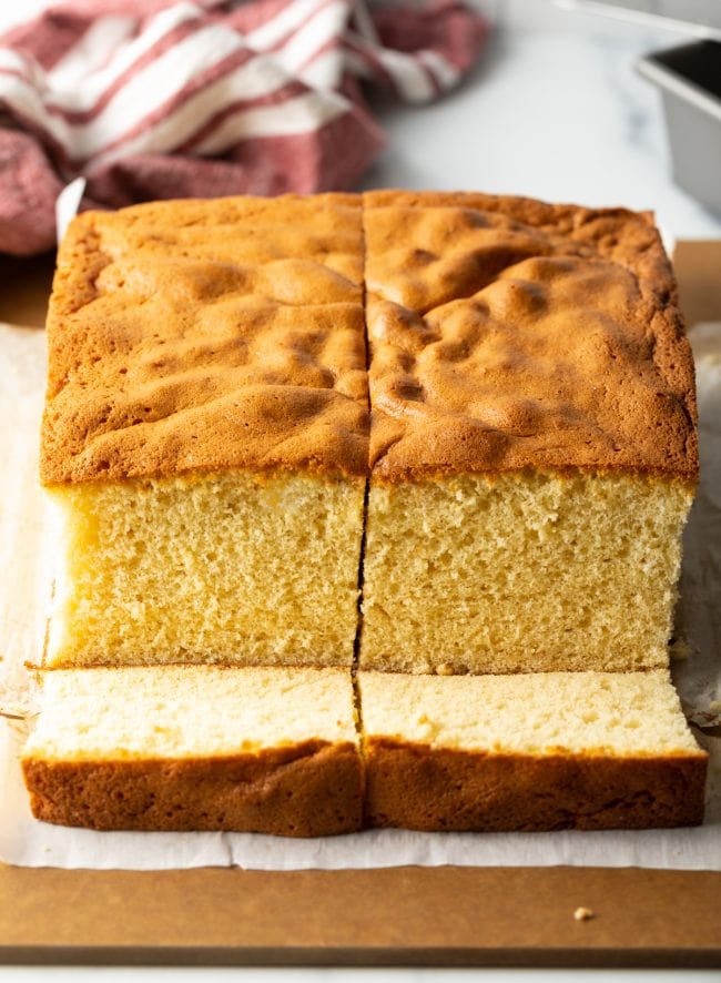 A cross section of Japanese Sponge Cake sliced down the middle. Two slices are also cut out of the cake.