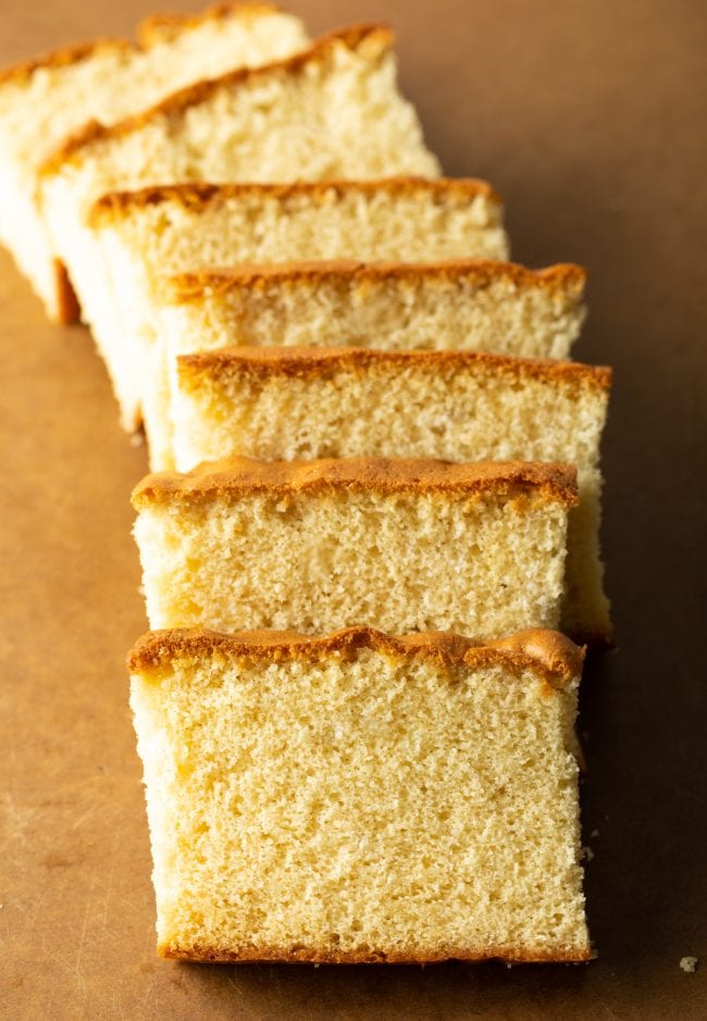 top down view of slices of castella cake on a brown cutting board