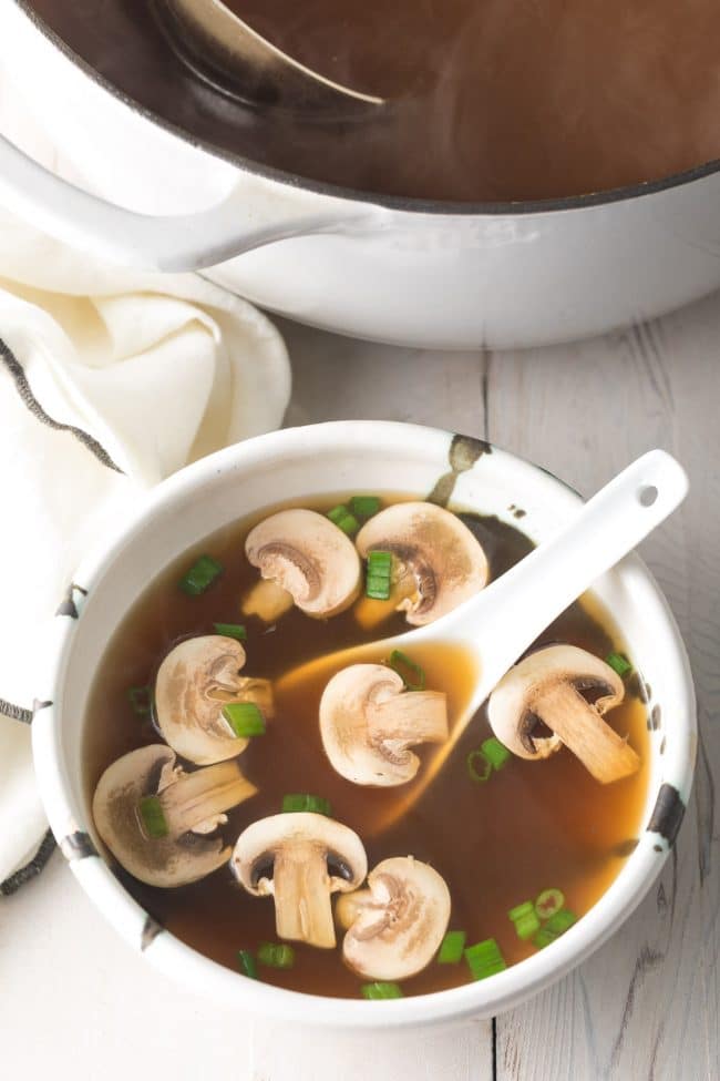 Best Japanese clear soup in a bowl with a white soup spoon. 