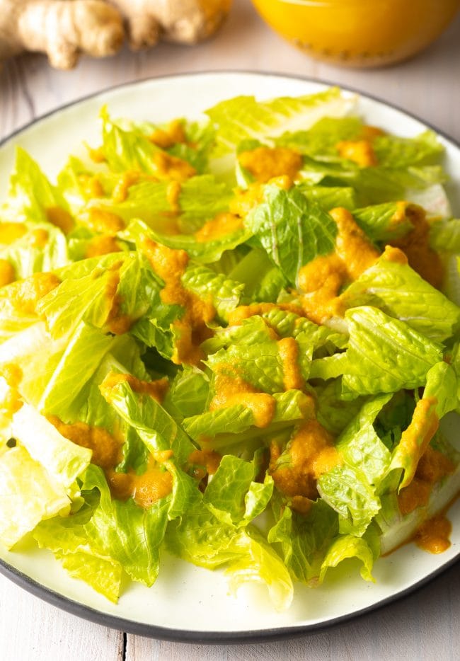 Ginger Salad Dressing on lettuce served on a plate. 