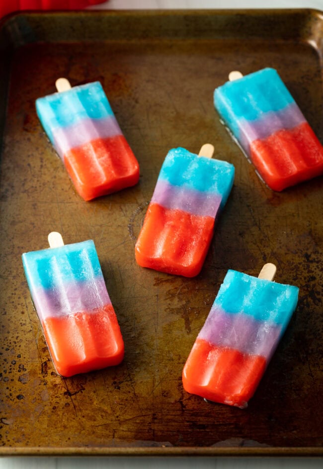 Top down 5 popsicles on a baking sheet.