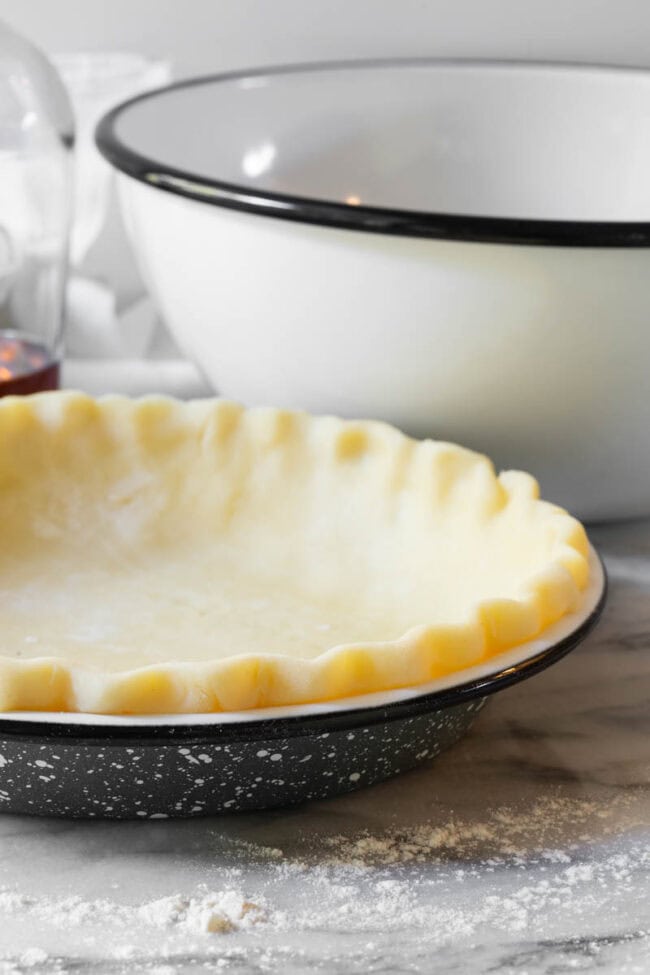 Raw pie crust in a pie pan.