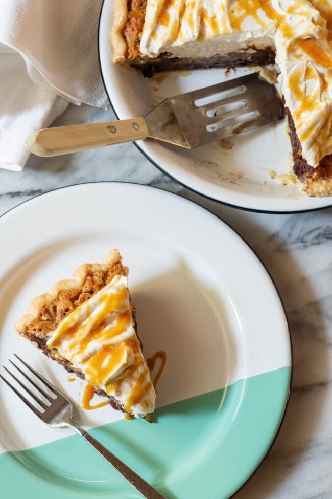 A slice of kentucky derby pie on a white and green plate.