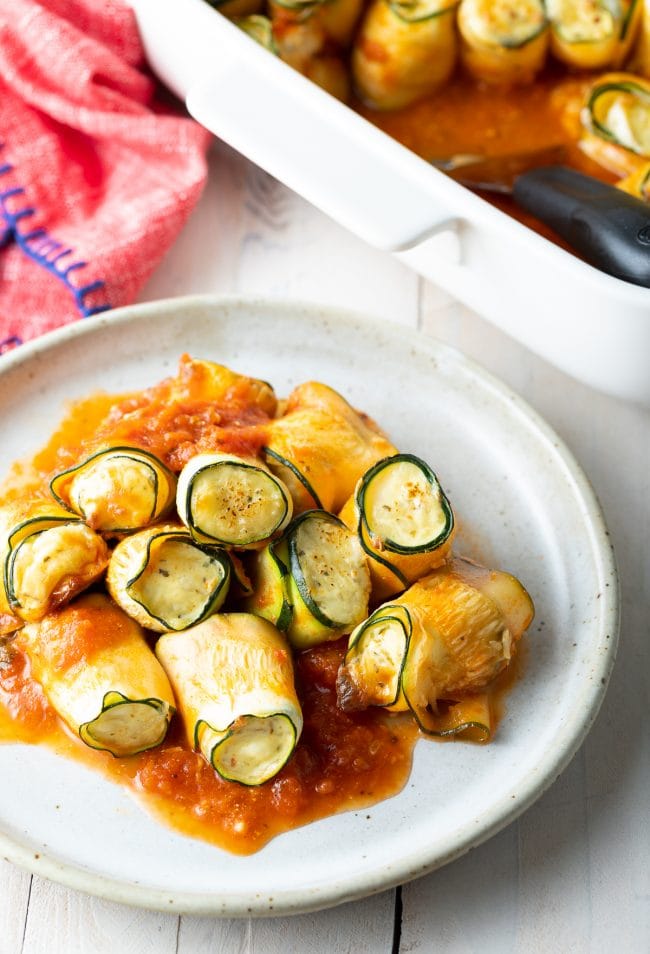 low carb zucchini roll-ups with tomato sauce on a plate. 