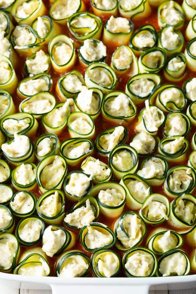 keto zucchini noodles stuffed with cheese in a baking dish, before being baked.