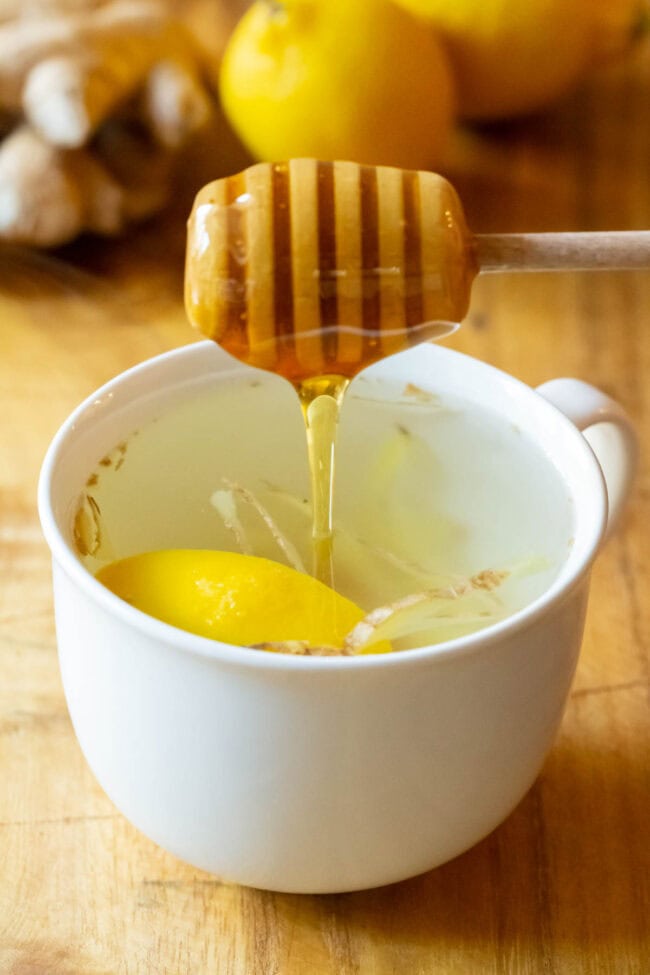 Adding honey to detox tea with a honey wand. 