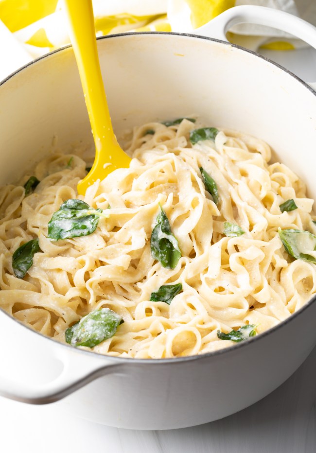 Noodles in a pot, with creamy lemon cheese sauce and fresh basil.