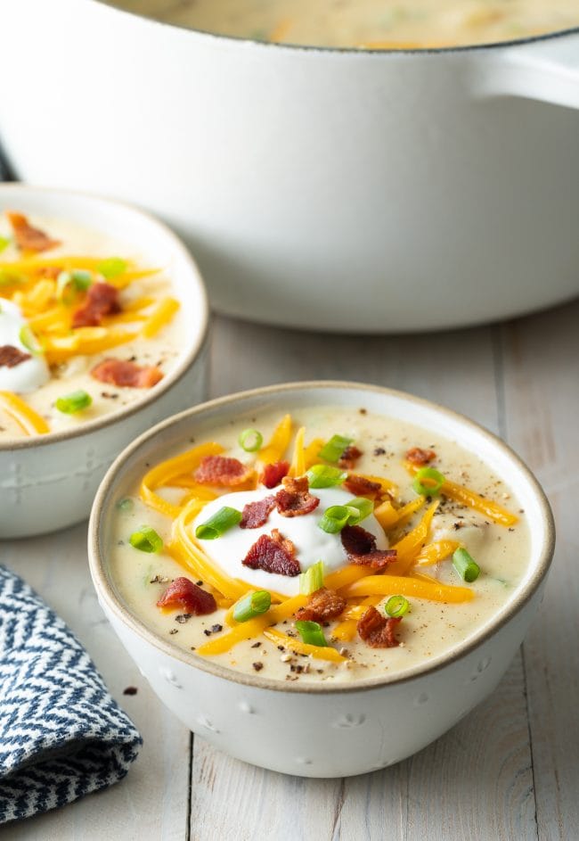 Bowl of loaded baked potato soup in a white bowl.