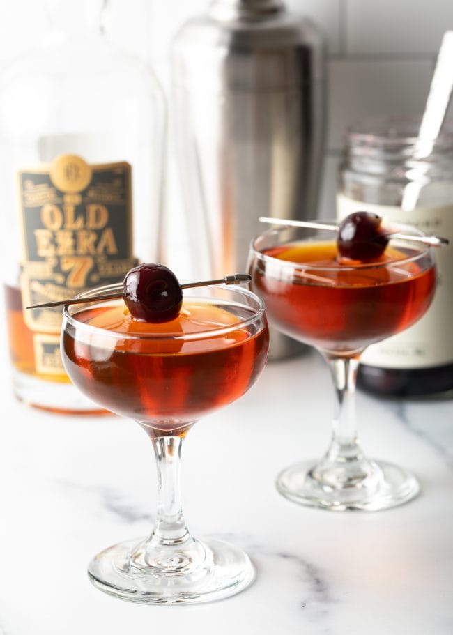 Two Manhattans both garnished with cherries. 