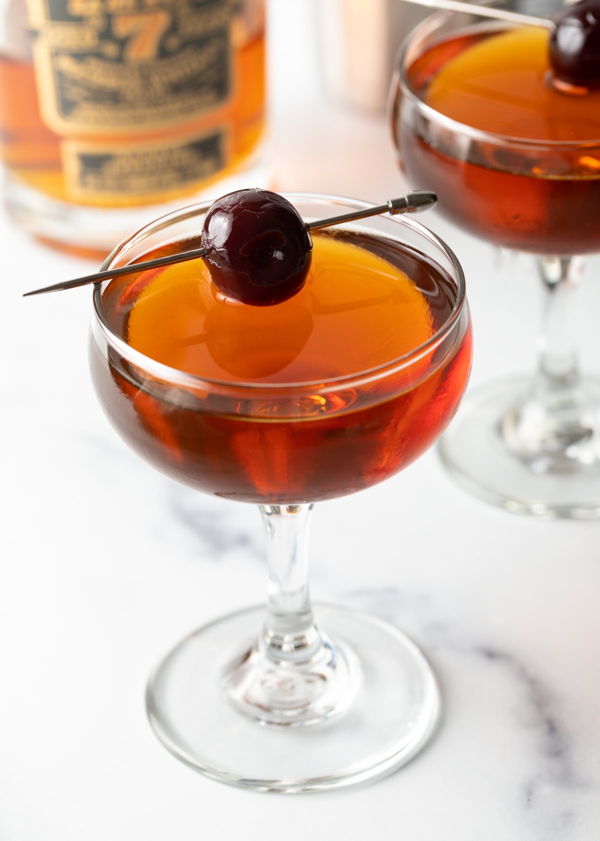 Cocktail in a coupe class with a cherry as garnish. 