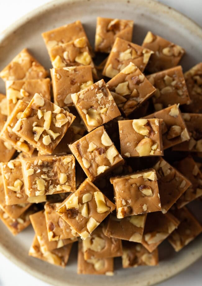 Top down view maple fudge stacked on a plate.