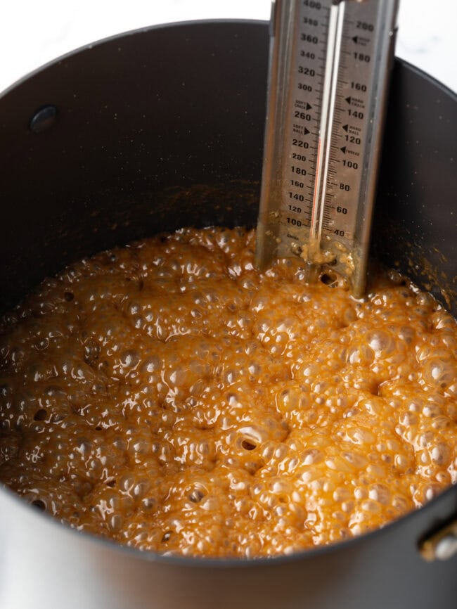 Maple syrup bubbling in a sauce pot with candy thermometer.