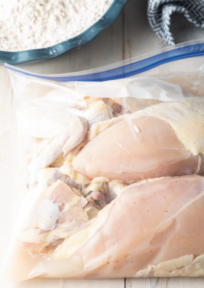 Chicken being brined in a ziplock bag in a pickle juice brine.