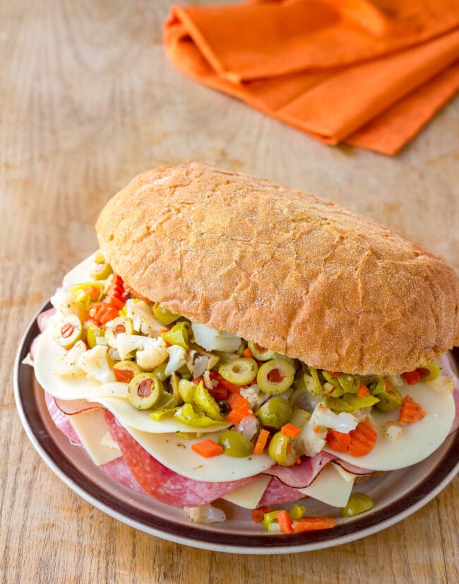 New Orleans Muffuletta on plate, loaded with meat, cheese and olive salad. 