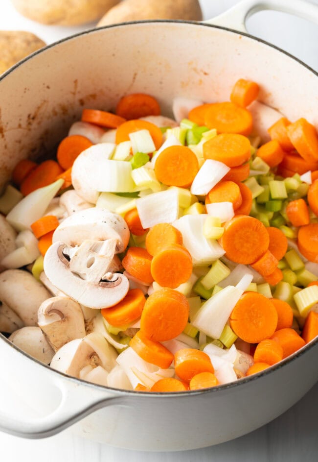 Chopped carrots, celery, onion, and potatoes in pot.