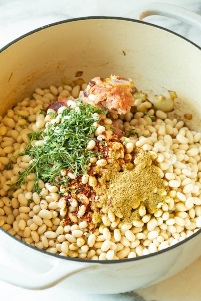 Added beans, spices and herbs to the dutch oven pot
