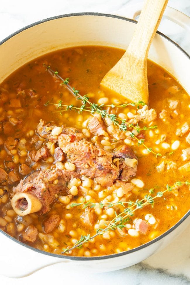 Navy Bean Soup - Big pot full of soup with a wooden spoon 
