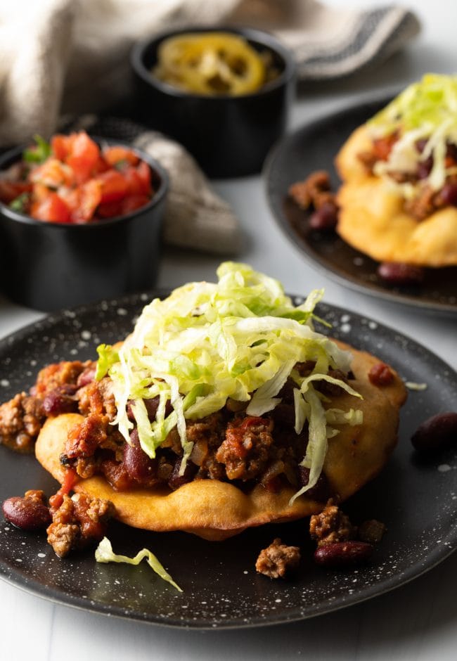 Assembling a crispy tortilla taco with meat and lettuce. 