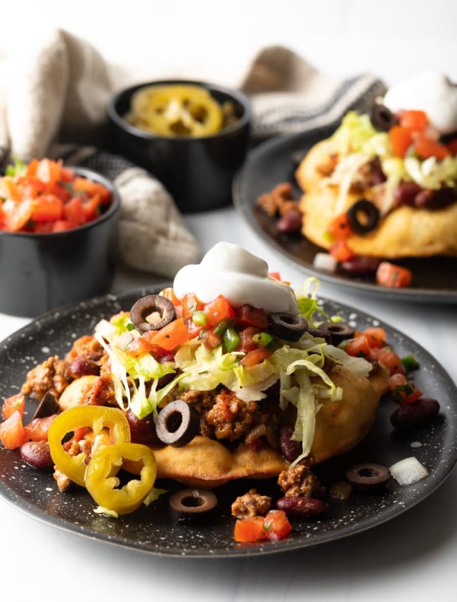 Indian tacos served on a black dish.