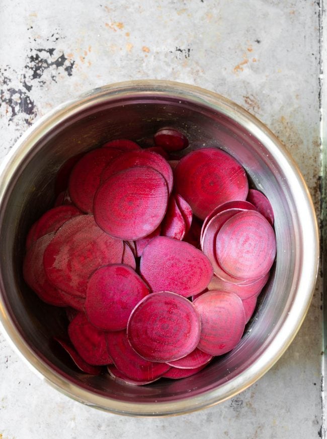 The beetroot “sweating” in salt and oil in a metal bowl to release moisture. 
