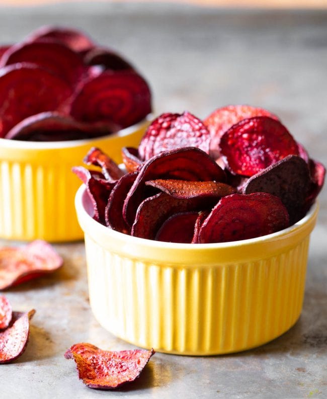 Final beet chips recipe looking crispy and bright in yellow bowls. 
