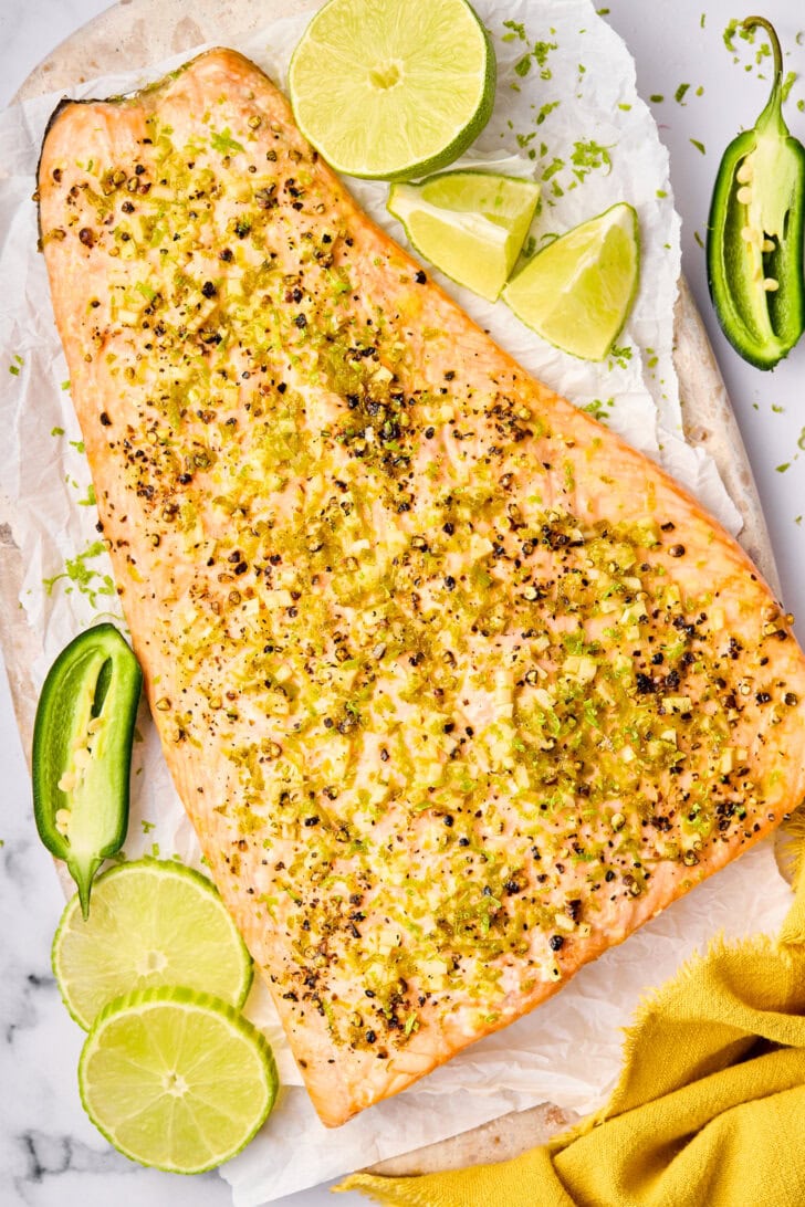 Overhead shot of oven baked salmon with lime and jalapeño. 