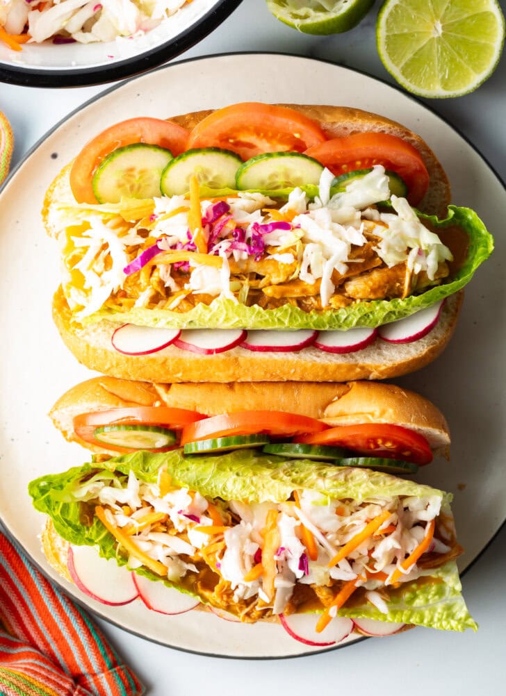 Two open pan con pollo each loaded with stewed chicken and veggies, side by side on a large plate.