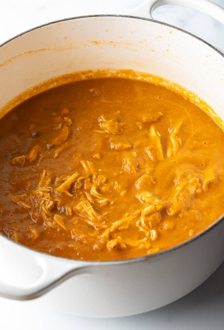 Stewed shredded chicken meat in a large pot.