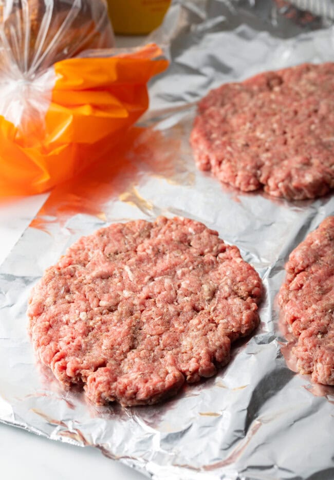 Raw burger patty on parchment.