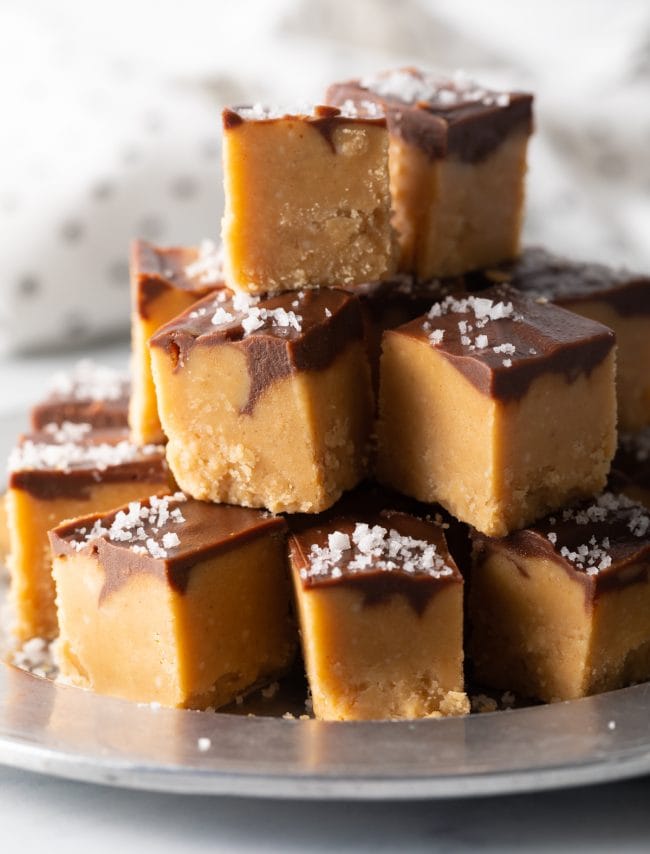 close view pieces of chocolate peanut butter fudge stacked on a plate