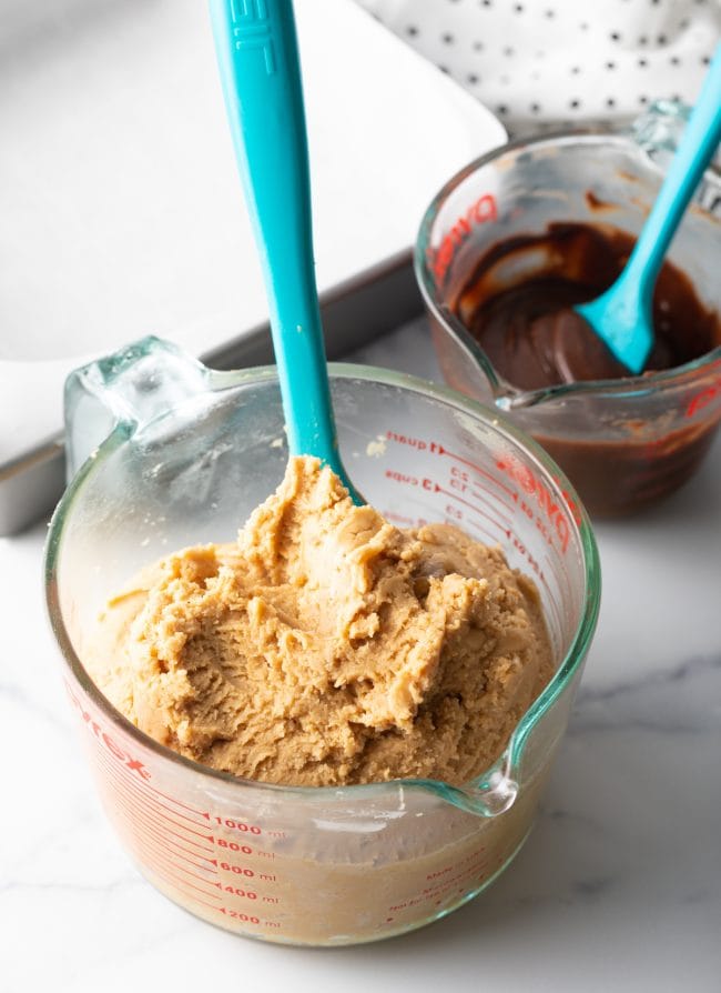 mixed fudge base in a large glass mixing cup with blue spatula