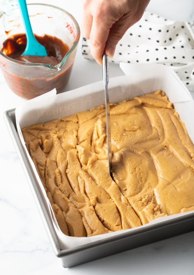 spread peanut butter mixture being swirled with a knife