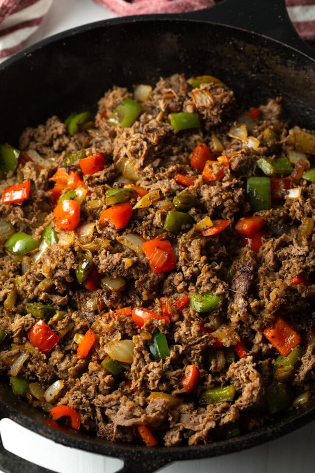 Cooked steak and peppers in a skillet.