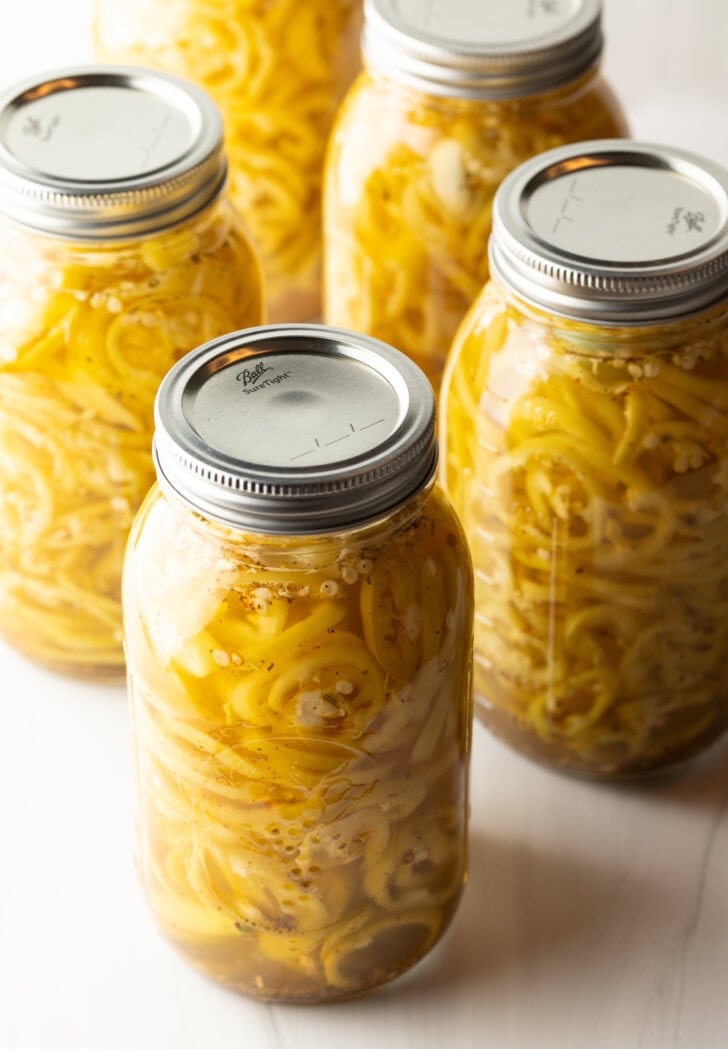 4 large sealed jars of canned pickled banana peppers.