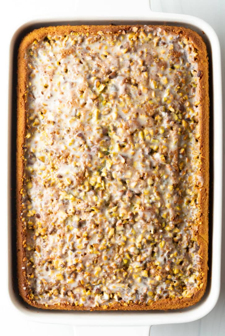 Top view baked pistachio poke cake with pistachios.