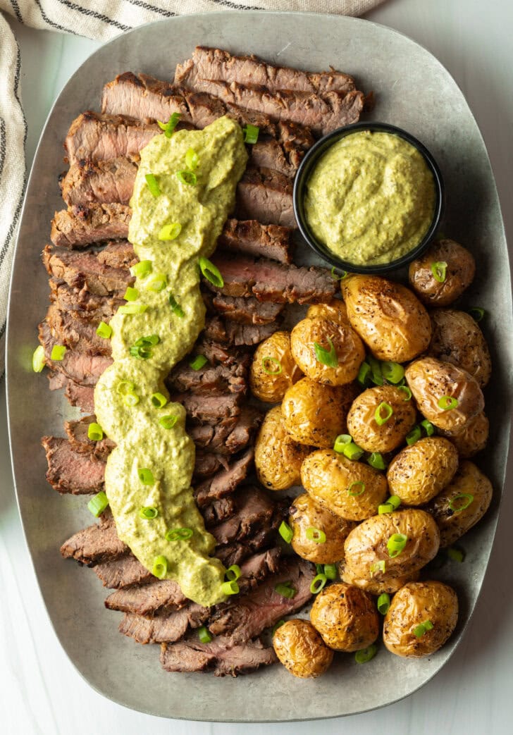 Strips of steak topped with creamy poblano sauce with a side of roasted baby potatoes.