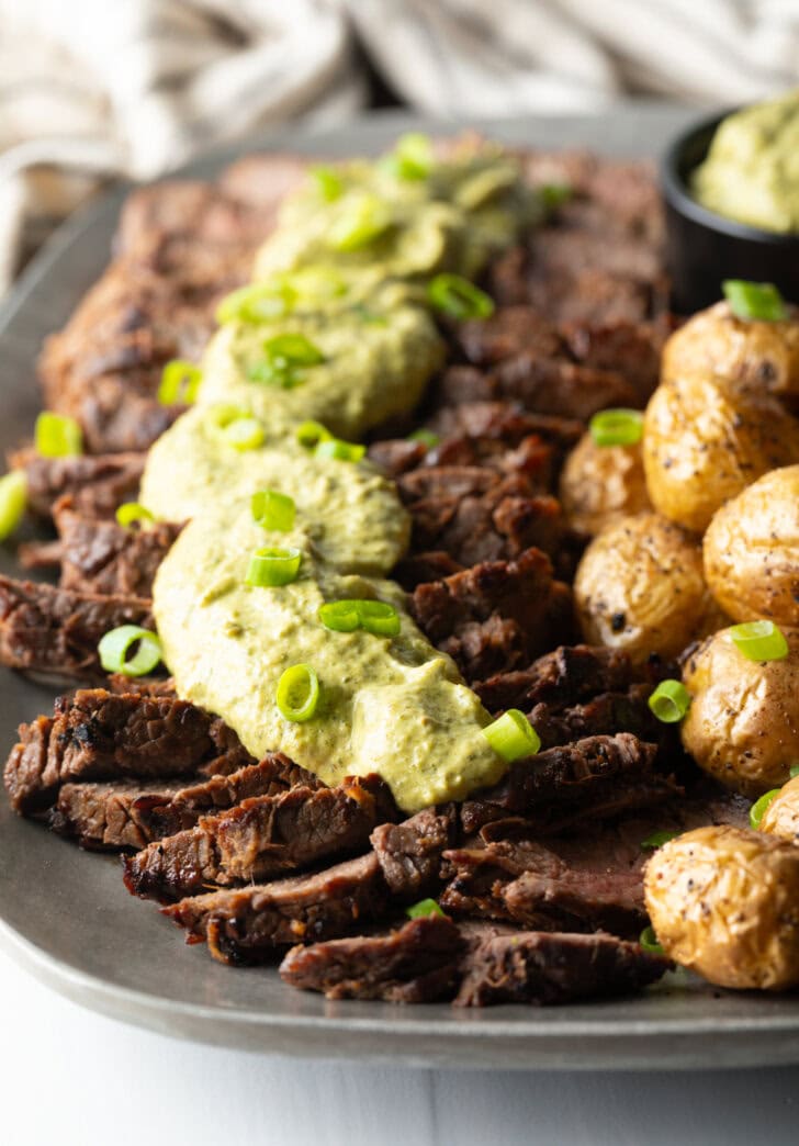 Strips of steak topped with creamy poblano sauce with a side of roasted baby potatoes.