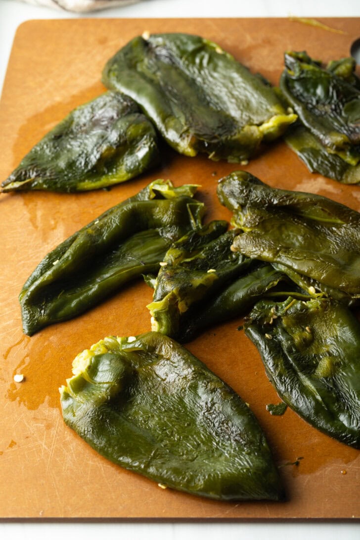 8 roasted poblano pepper on a cutting board, seeds having been removed.