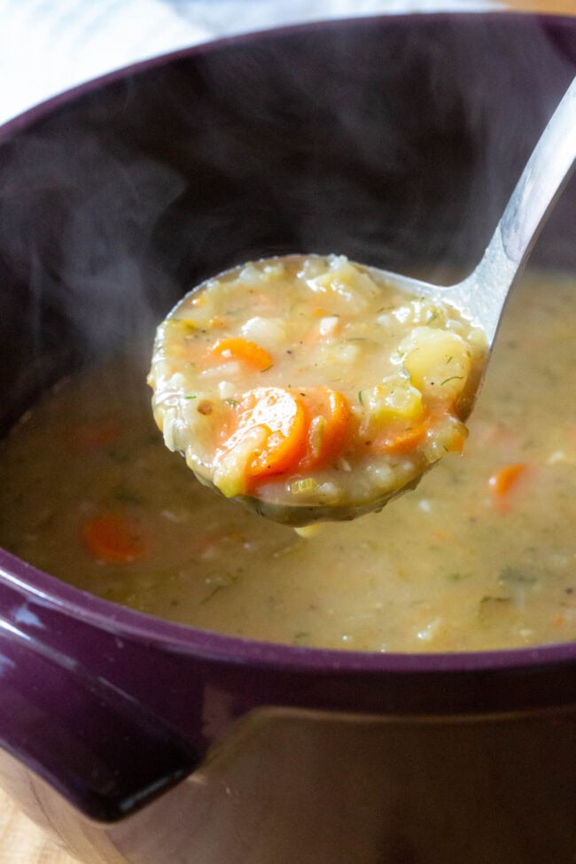 Dill Pickle Soup scooped up in ladle.