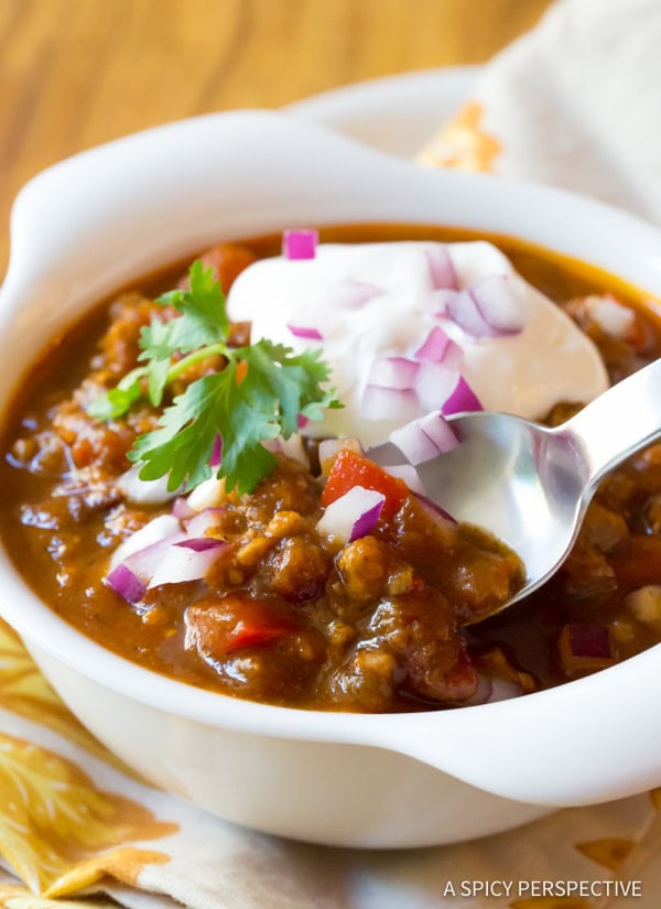 Bowl of pumpkin chili with a silver spoon in the bowl. 