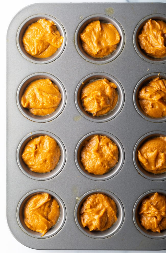 Muffin batter filling a 12 cup baking pan.