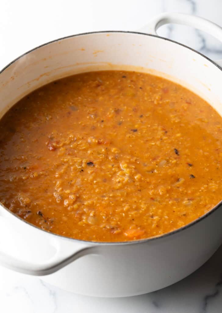 Large cooking pot with lentil and carrot soup.