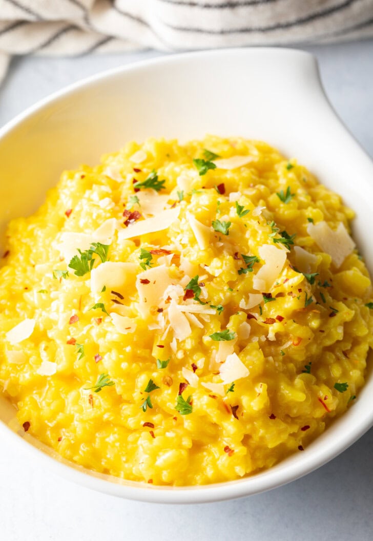 White bowl of saffron risotto milanese.