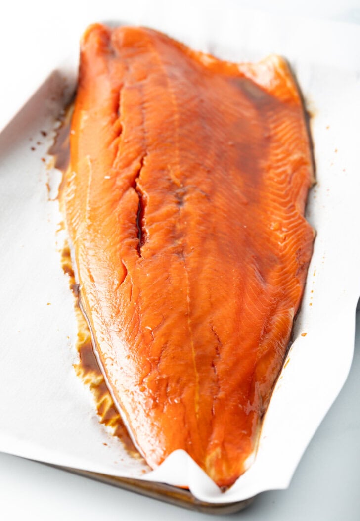 Side of cooked salmon on parchment.